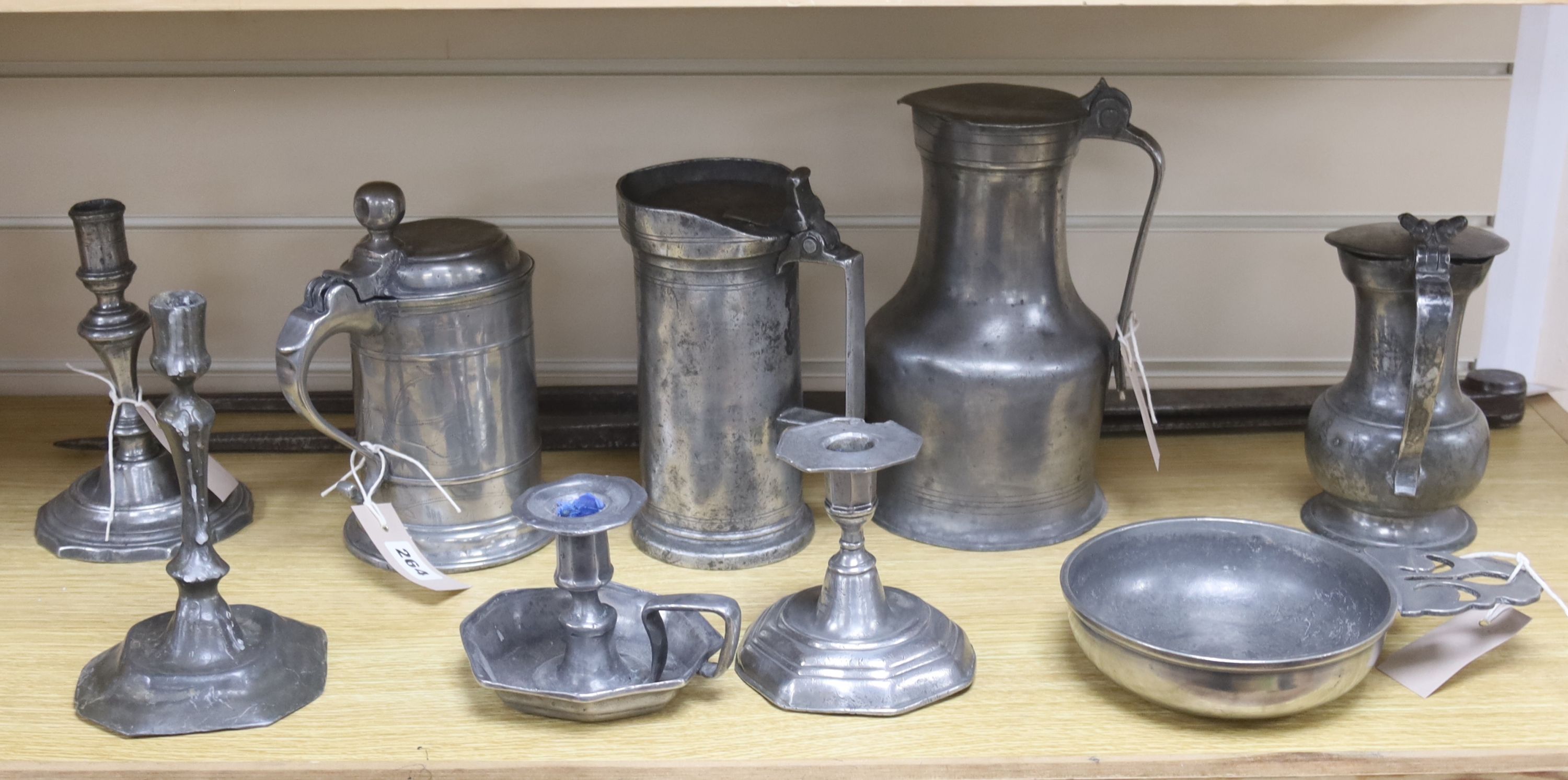 A large pair of steel dividers and a collection of 18th/19th century Continental pewter, including four various flagons, three candlesticks, a chamberstick and a porringer